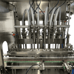 High-speed automated piston filling machine on a production line.
