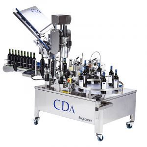 Automated labeling machine applying labels to bottles.